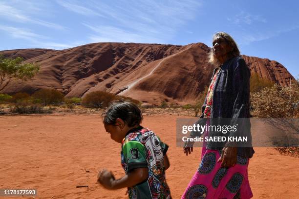 Traditional Aboriginal owners of Uluru-Kata-Tjuta, the Anangu, gather in front of the Uluru, also known as Ayers rock, after a permanent ban on...