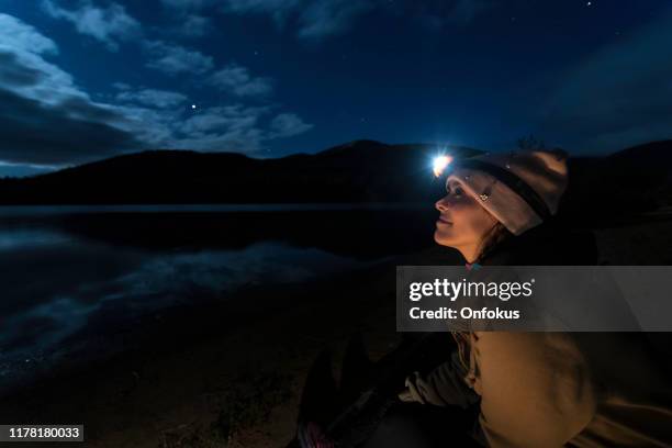 young woman looking at the clear sky at night in camping. - electric torch stock pictures, royalty-free photos & images