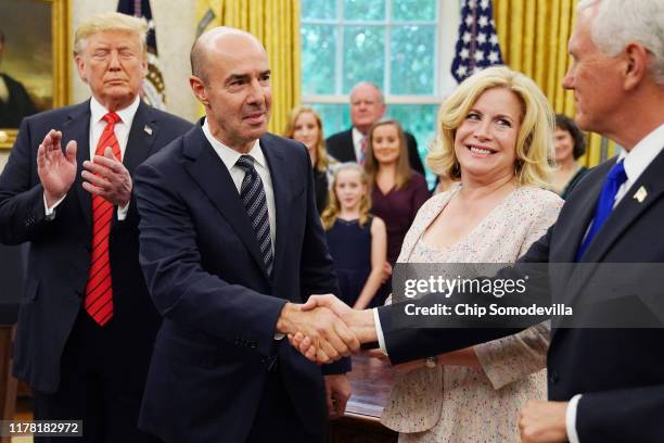 President Donald Trump applauds as Labor Secretary Eugene Scalia is congratulated by Vice President Mike Pence as his wife Patricia Scalia looks on...