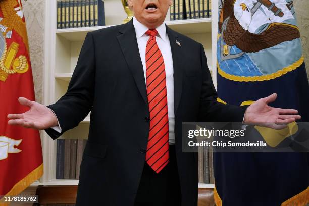 President Donald Trump gives pauses to answer a reporters' question about a whistleblower as he leaves the Oval Office after hosting the ceremonial...