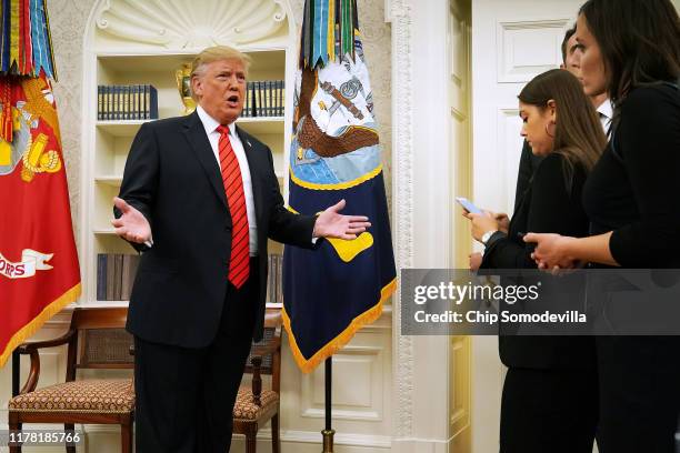 President Donald Trump gives pauses to answer a reporters' question about a whistleblower as he leaves the Oval Office after hosting the ceremonial...