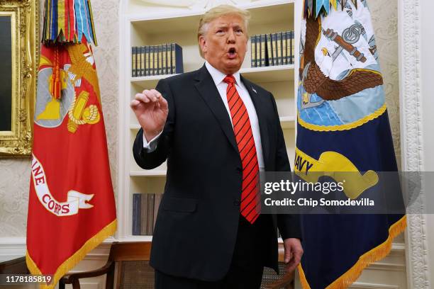 President Donald Trump gives pauses to answer a reporters' question about a whistleblower as he leaves the Oval Office after hosting the ceremonial...