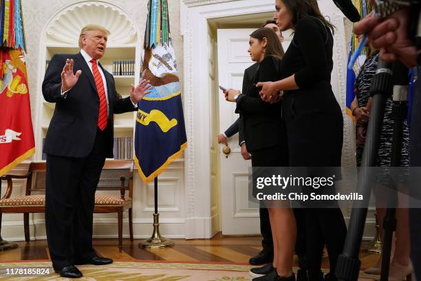 President Donald Trump gives pauses to answer a reporters' question about a whistleblower as he leaves the Oval Office after hosting the ceremonial...