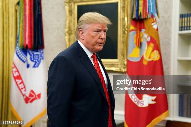 President Donald Trump gives pauses to answer a reporters' question about a whistleblower as he leaves the Oval Office after hosting the ceremonial...