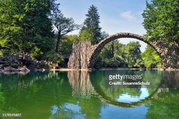 devil's bridge in the nature park with circle reflection in the water - bogen stock pictures, royalty-free photos & images