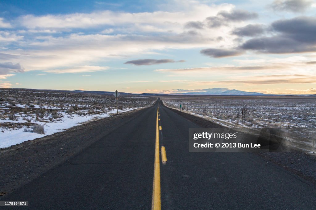 Straight road ahead with vibrant sunset sky