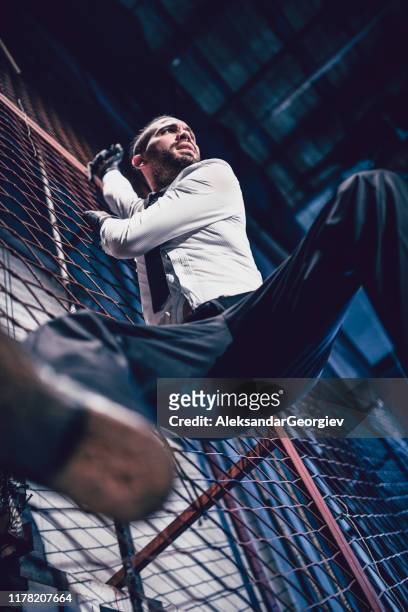 handsome male hanging on a thread - fences film stock pictures, royalty-free photos & images