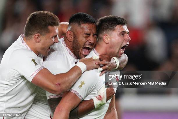 Ben Youngs of England celebrates with team mates Manu Tuilagi and Henry Slade after scoring his side's second try, which was later disallowed during...