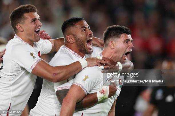 Ben Youngs of England celebrates with team mates Manu Tuilagi and Henry Slade after scoring his side's second try, which was later disallowed during...