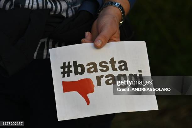 Person holds a placard reading "Raggi no more", referring to current Rome mayor Virginia Raggi, of the M5S Five Star movement, during a peaceful...