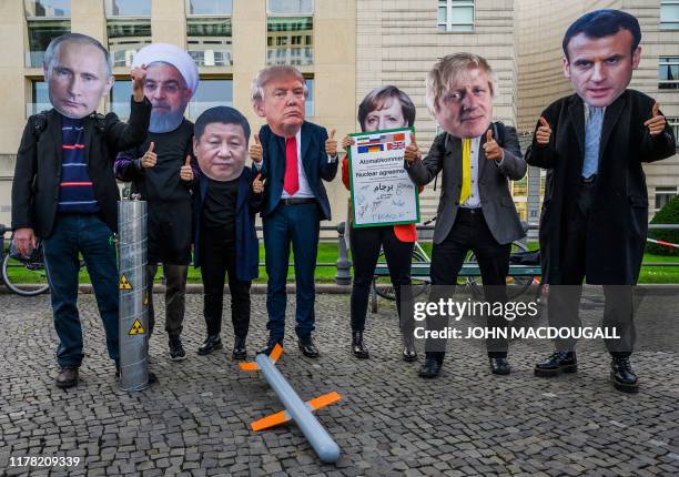 Peace activists wearing masks of Russian President Vladimir Putin, Iranian President Hassan Rouhani, Chinese leader Xi Jiping, US President Donald...