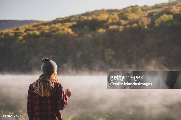 ung kvinna vandring med kaffe - forest day bildbanksfoton och bilder