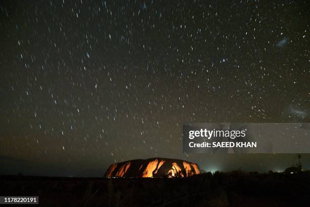 Stars trails are seen over Uluru, also known as Ayers rock, after a permanent ban on climbing the monolith at the Uluru-Kata Tjuta National Park in...