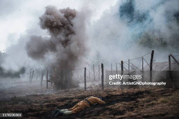 death soldier laying on battle field. - campo de batalha imagens e fotografias de stock