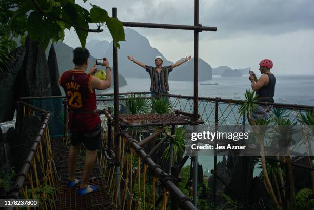 Tourists Tourists climb a rock formation on a hill, on September 16, 2019 in El Nido, Philippines. The island of Palawan in the Philippines took 1.8...