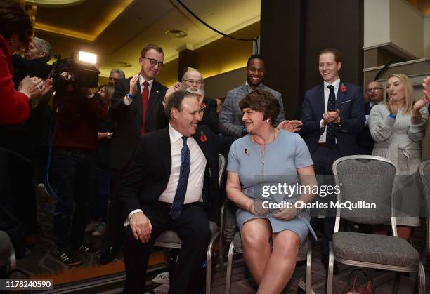 Leader Arlene Foster sits along side deputy leader Nigel Dodds as she receives a standing ovation from party members after her speech during the...