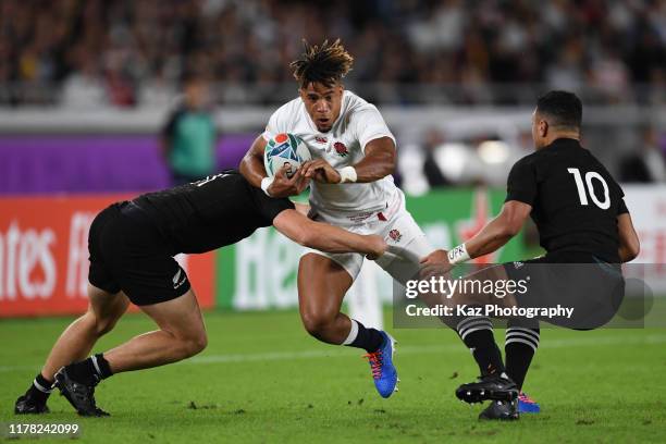 Anthony Watson of England advances with the ball while Richie Mo'unga of New Zealand tackles during the Rugby World Cup 2019 Semi-Final match between...