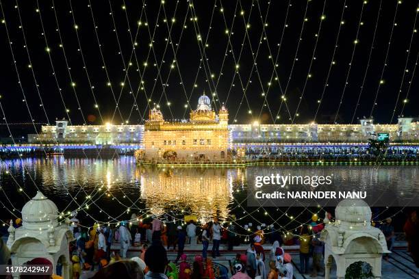 Indian Sikh devotees pay their respects on the eve of "Bandi Chhor Divas" or "Diwali" at the illuminated Golden Temple, in Amritsar on October 26,...