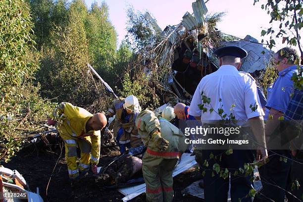 Rescue workers prepare to remove the charred body of plane crash victim from the wreckage of the Il-86 cargo plane which crashed at Sheremetyevo-1...