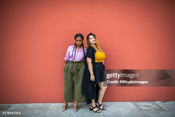 due belle ragazze che guardano la telecamera. - community figures foto e immagini stock