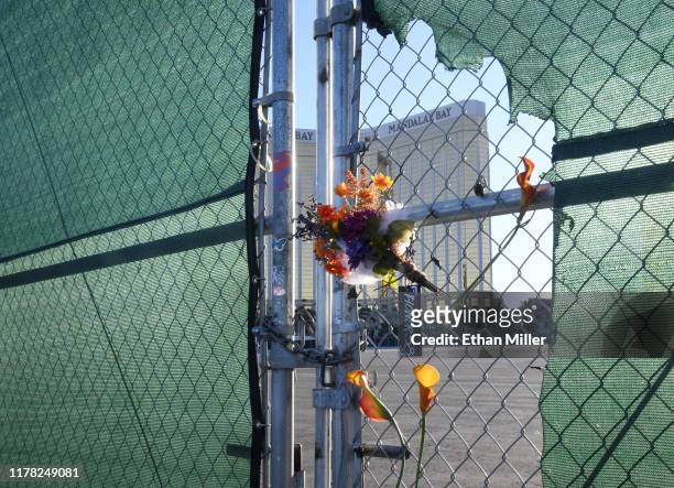 Flowers and a sign reading "HONOR 58" hang on a fence outside the Las Vegas Village across from Mandalay Bay Resort and Casino as a tribute to those...