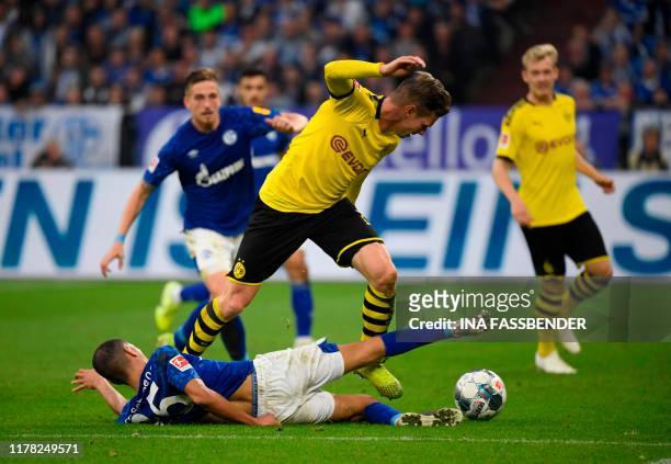 Schalke's French midfielder Amine Harit and Dortmund's Polish defender Lukasz Piszczek vie for the ball during the German First division Bundesliga...