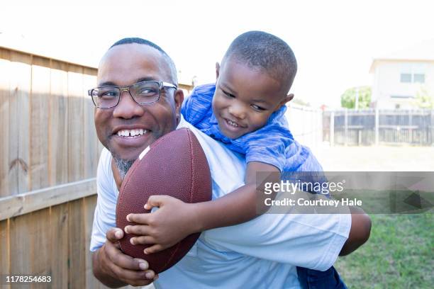 father and young boy playing football outside - playing catch stock pictures, royalty-free photos & images
