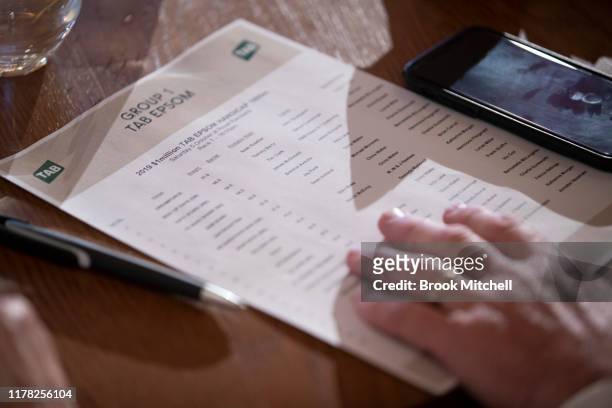 Punter reads the form as balls are drawn during the TAB Epson Barrier Draw at Royal Randwick Racecourse on October 01, 2019 in Sydney, Australia.