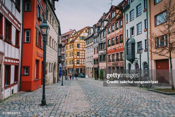 idyllic view tourist walking of row houses on street, weissgerbergasse in nuremberg city, german - nuremberg stock pictures, royalty-free photos & images