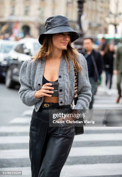 Guest is seen wearing cropped cardigan, bag, floppy hat, black leather pants outside Stella McCartney during Paris Fashion Week Womenswear Spring...