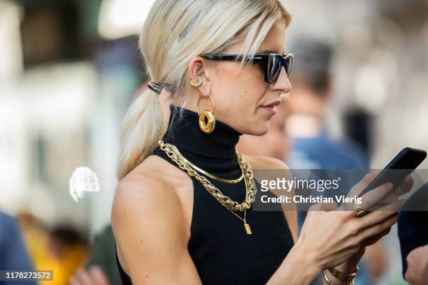 Caroline Caro Daur seen wearing jewellery: golden earrings, necklace and ring, sunglasses outside Sacai during Paris Fashion Week Womenswear Spring...