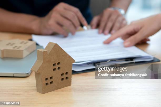 customer signing a real estate contract in real estate agency. - mortgage agreement stock pictures, royalty-free photos & images