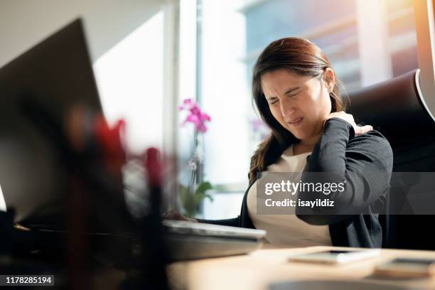 tired businesswoman holding her nape - nape of neck stock pictures, royalty-free photos & images