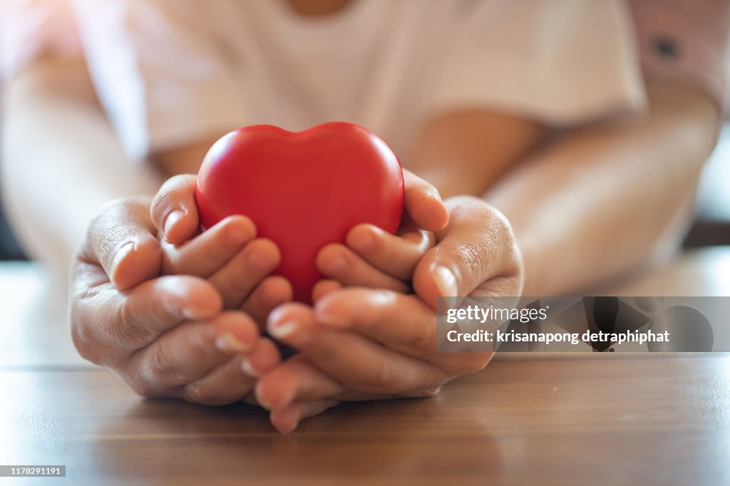 Adult and child hands holding red heart, health care, donate and family insurance concept,world heart day, world health day,