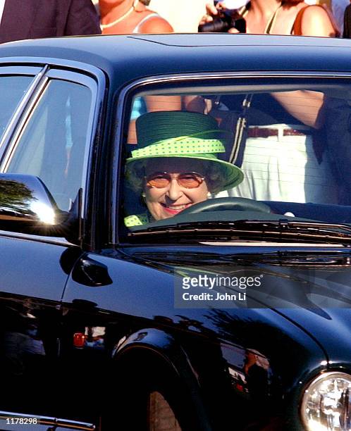 The Queen Of England drives her Jaguar car, as she leaves the Cartier International Day, held at the Guards Polo Club July 28, 2002 in Windsor,...