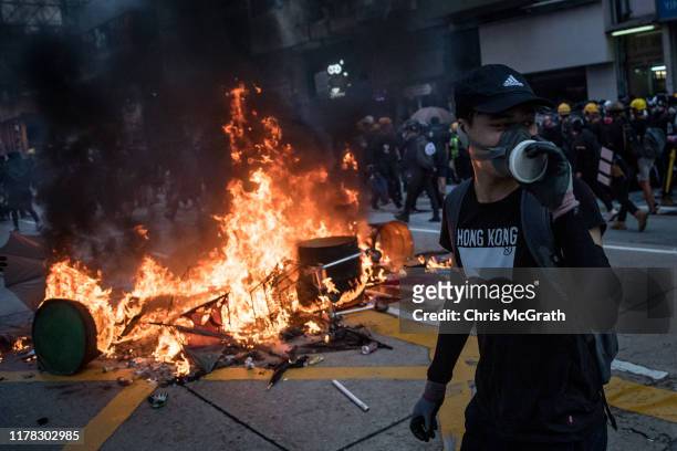 Pro-democracy protester walks in front of a burning barricade during clashes with police in Wan Chai on October 01, 2019 in Hong Kong, China....