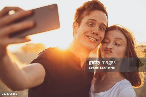 couple taking funny selfie on the beach in santa monica - flirting funny stock pictures, royalty-free photos & images