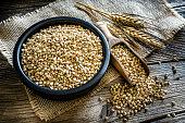Dietary fiber: wholegrain buckwheat in a black bowl on rustic wooden table