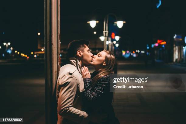 besar en la calle de la noche - beso en la boca fotografías e imágenes de stock