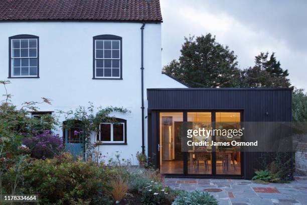 modern extension built onto the side of a listed period property. - illuminated house stock pictures, royalty-free photos & images