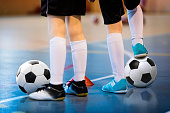 Futsal soccer training. Two young futsal players with balls on training. Close up of legs of futsal footballers