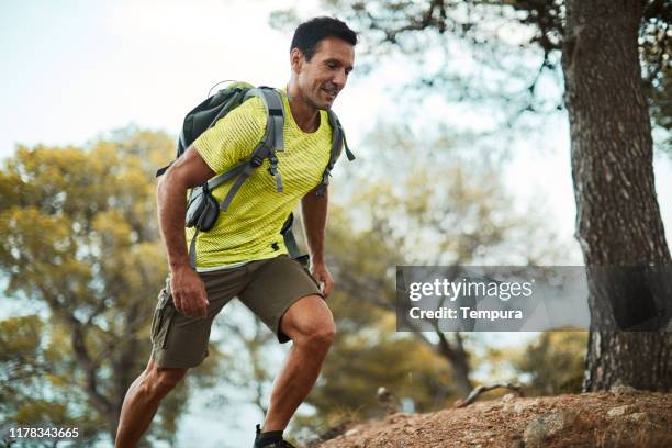 hombre adulto medio corriendo a través del país. - cross country running fotografías e imágenes de stock