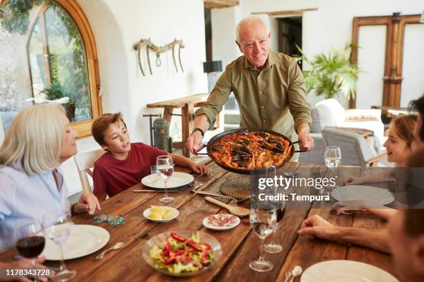 grandfather shows with pride his paella. - povo espanhol e povo português imagens e fotografias de stock