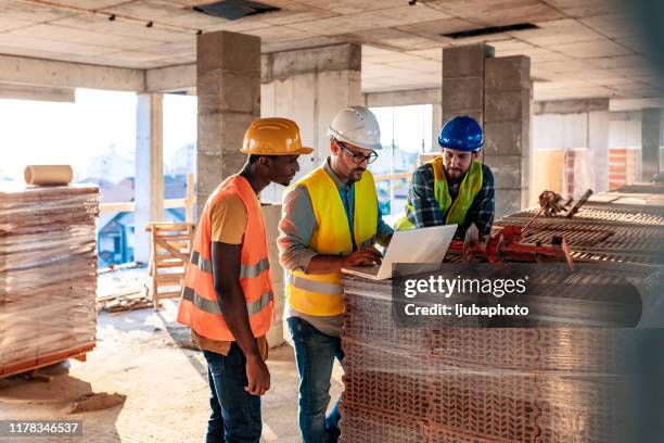 arbeiter auf baustelle im gebäude - under construction stock-fotos und bilder