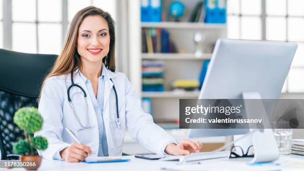 medico donna sorridente nella sua clinica - chirurgo plastico foto e immagini stock