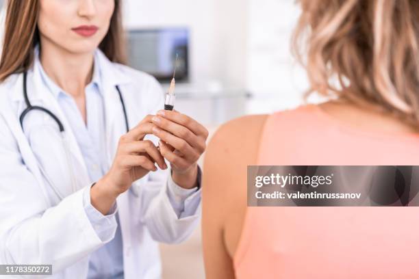 vrouwelijke arts die een patiënt vaccineert - gele koorts stockfoto's en -beelden