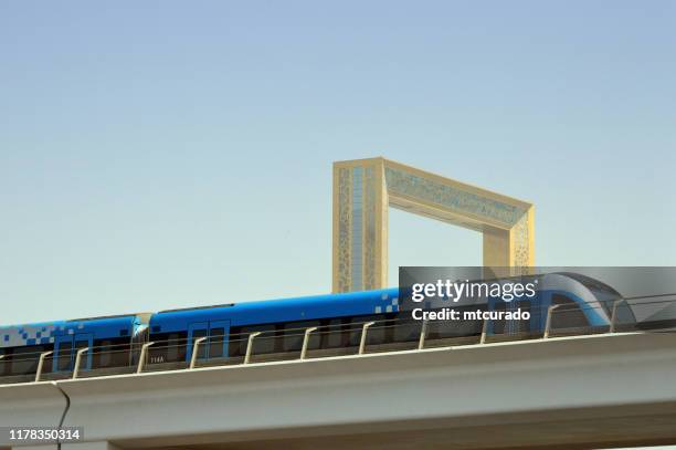 dubai frame en trein op de dubai metro verhoogde spoorlijn, dubai, verenigde arabische emiraten - dubai frame stockfoto's en -beelden