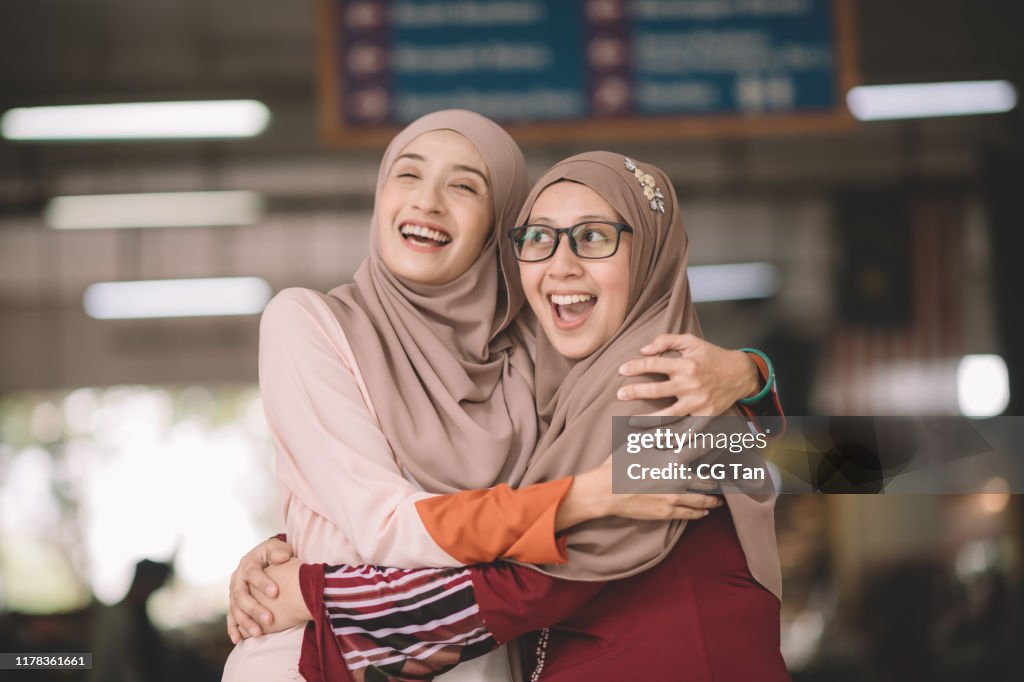 Two muslim female malay ladies friend met up at wet market in the morning and greeting to each other