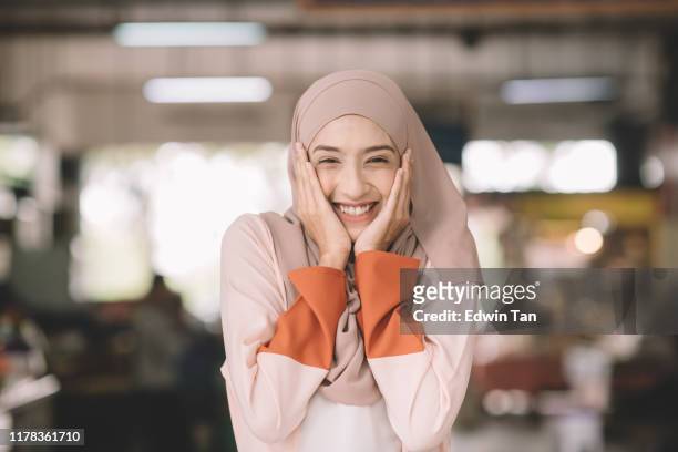eine asiatische muslimische weibliche kopfschuss auf nassen markt am morgen im freien mit positiven emotionen - malaysian culture stock-fotos und bilder
