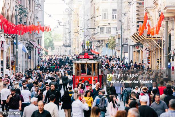 istiklal avenue with old red tram and crowds of people, istanbul, turkey - istanbul stock-fotos und bilder